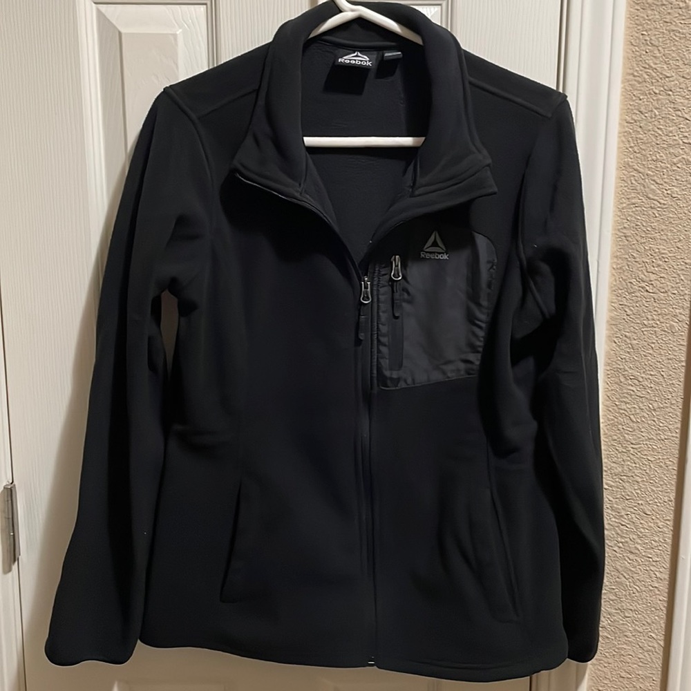 Woman’s Reebok black zip up jacket with side pockets. Size M